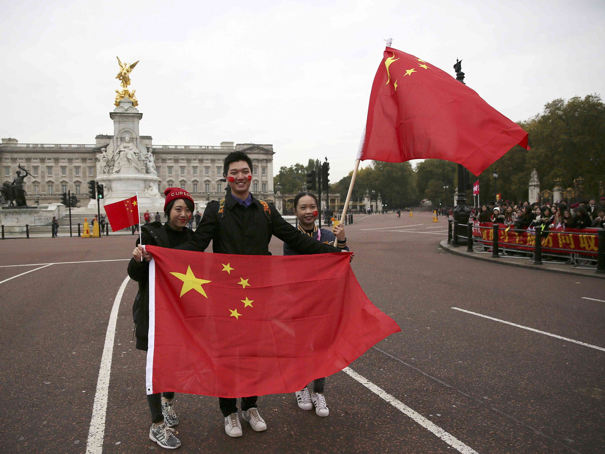 Supporters of China's President Xi Jinping wait on the Mall for him to pass during his ceremonial welcome, in London, 20 October 2015