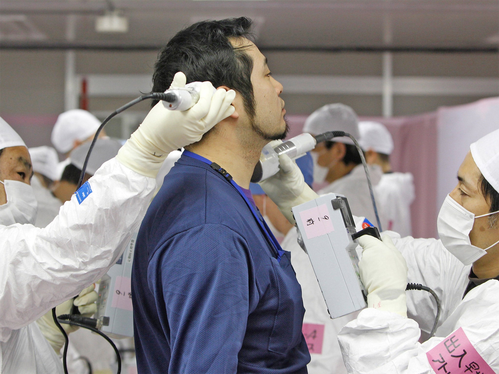 A worker undergoes radiation screening as he enters the emergency operation centre at the Fukushima Daiichi plant in February 2012, 11 months after the catastrophe