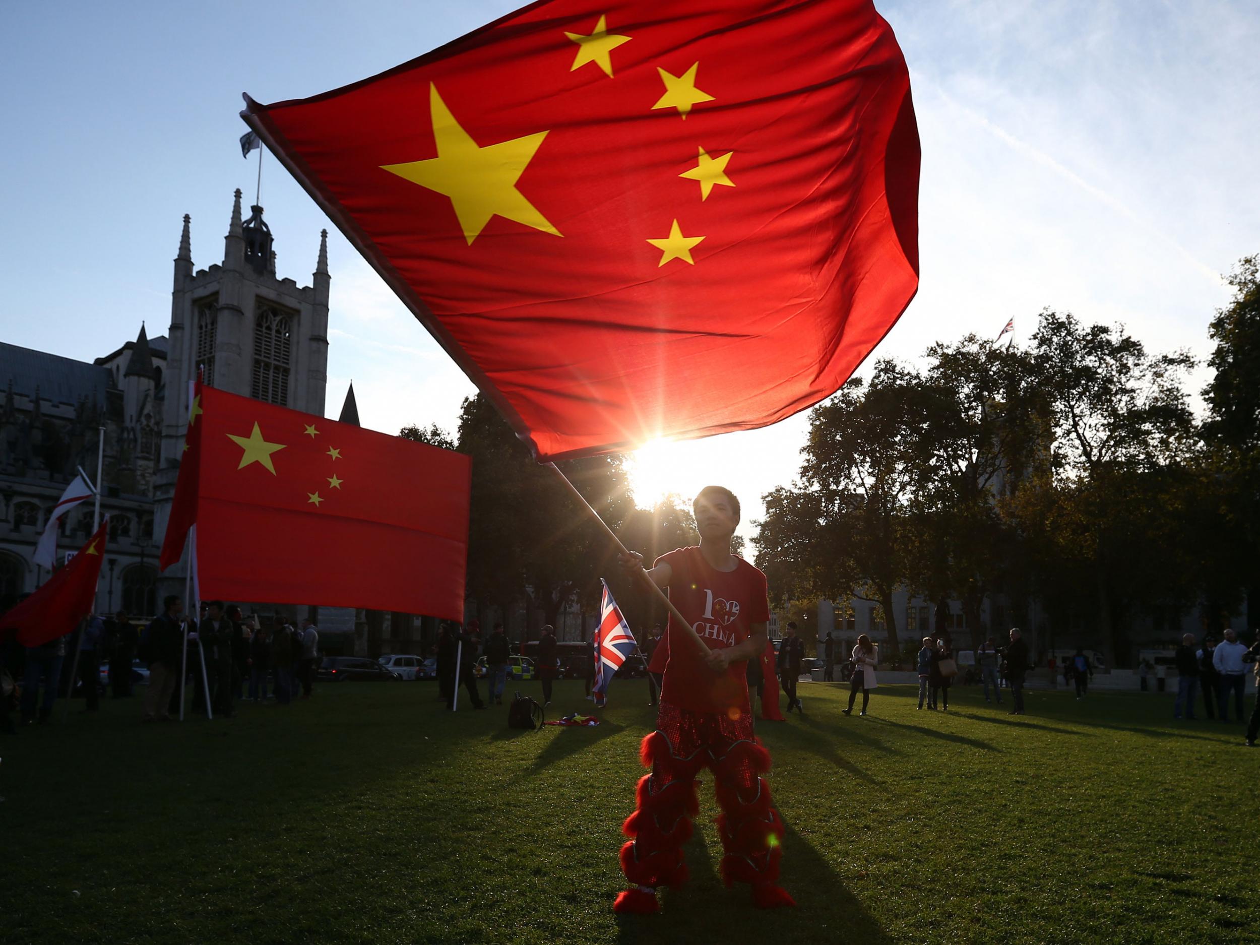 A pro-China activist waves a Chinese flag as he demonstrates near Parliament ahead of a visit by China's President, Xi Jinping on October 20, 2015 in London