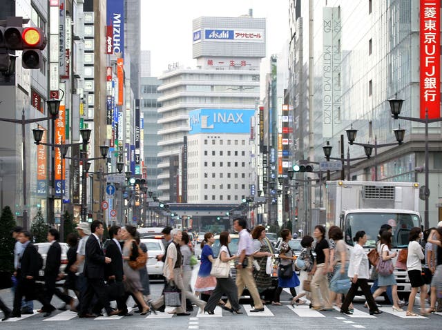 People walk across the street in the Ginza district in Tokyo