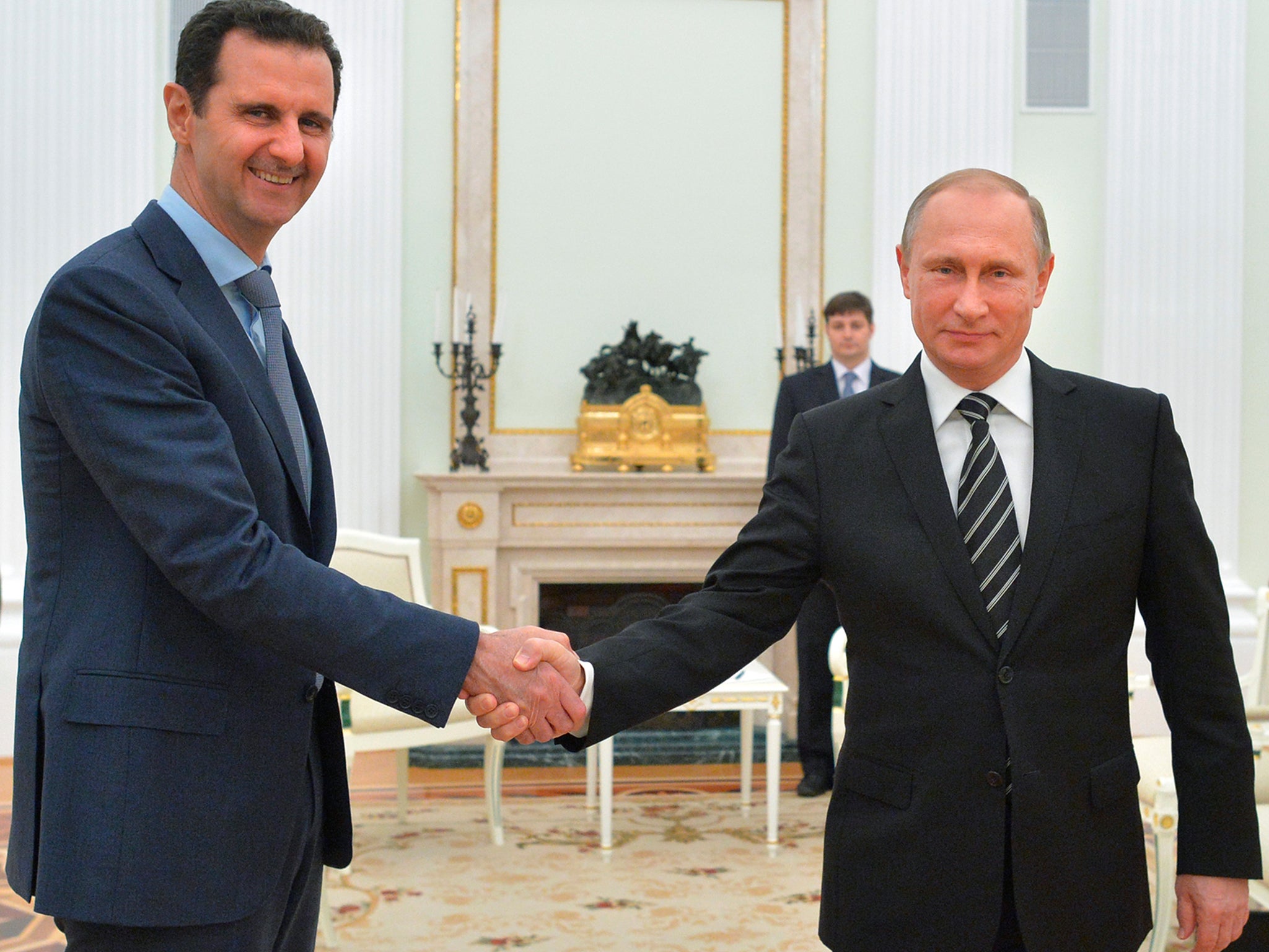 Russian President Vladimir Putin shakes hand with Syrian President Bashar Assad in the Kremlin in Moscow, Russia