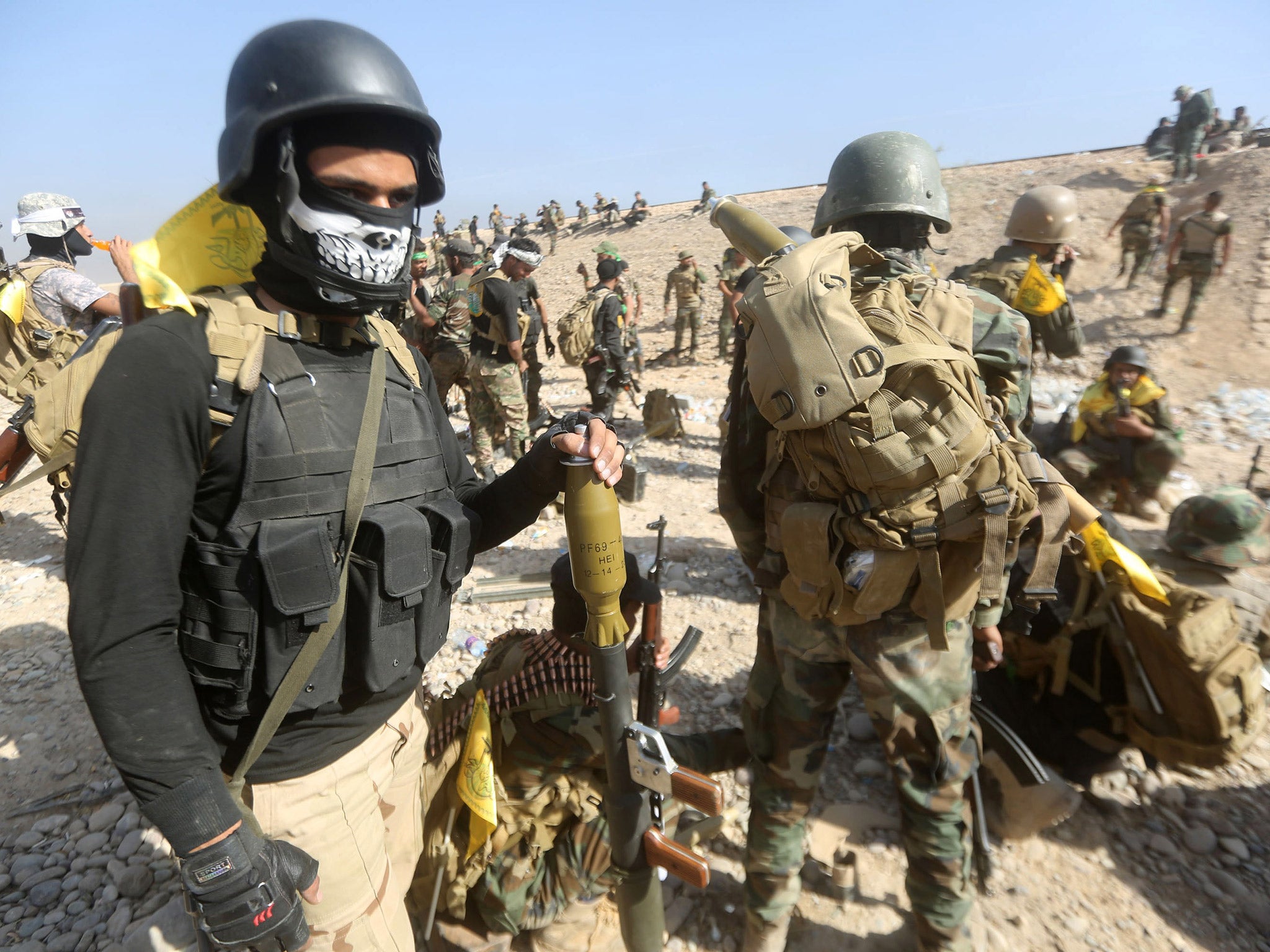 Shia fighters, alongside Iraqi forces, regroup as they advance towards the centre of Baiji last weekend (Getty)