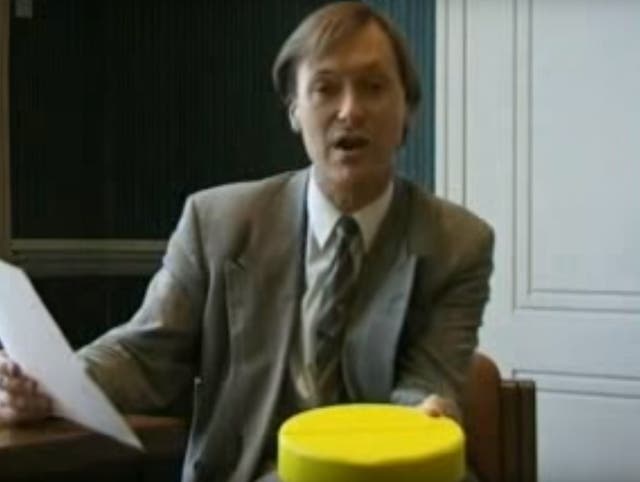 David Amess holds a piece of 'Cake' for the camera