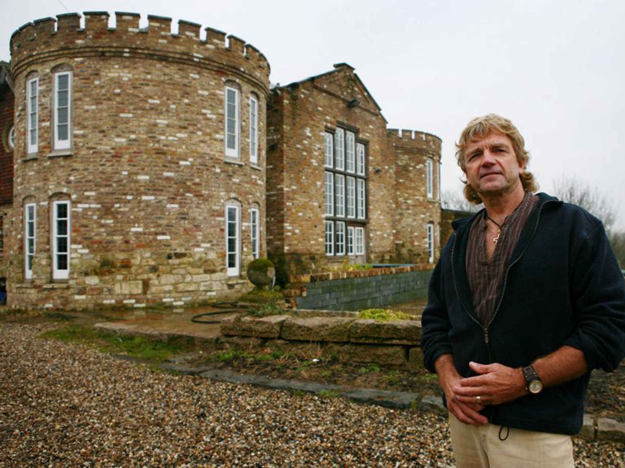 Robert Fidler outside the condemned home in Surrey that he built without planning permission