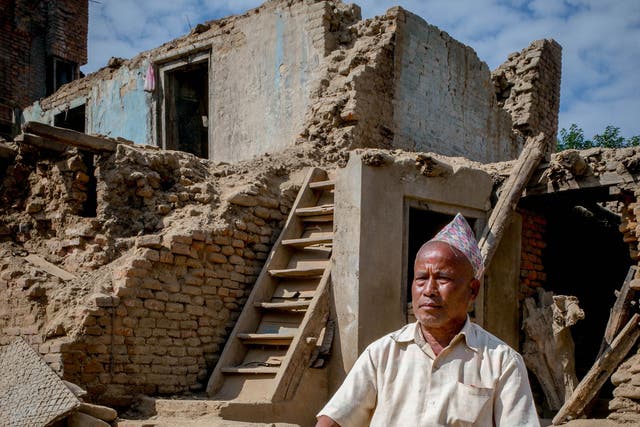 Panchamani Shakya, 66 ,sitting in a pile of rubble where his house once was – overlooking the once-magnificent, now-destroyed Machhendranath Temple in Bungamati, Nepal
