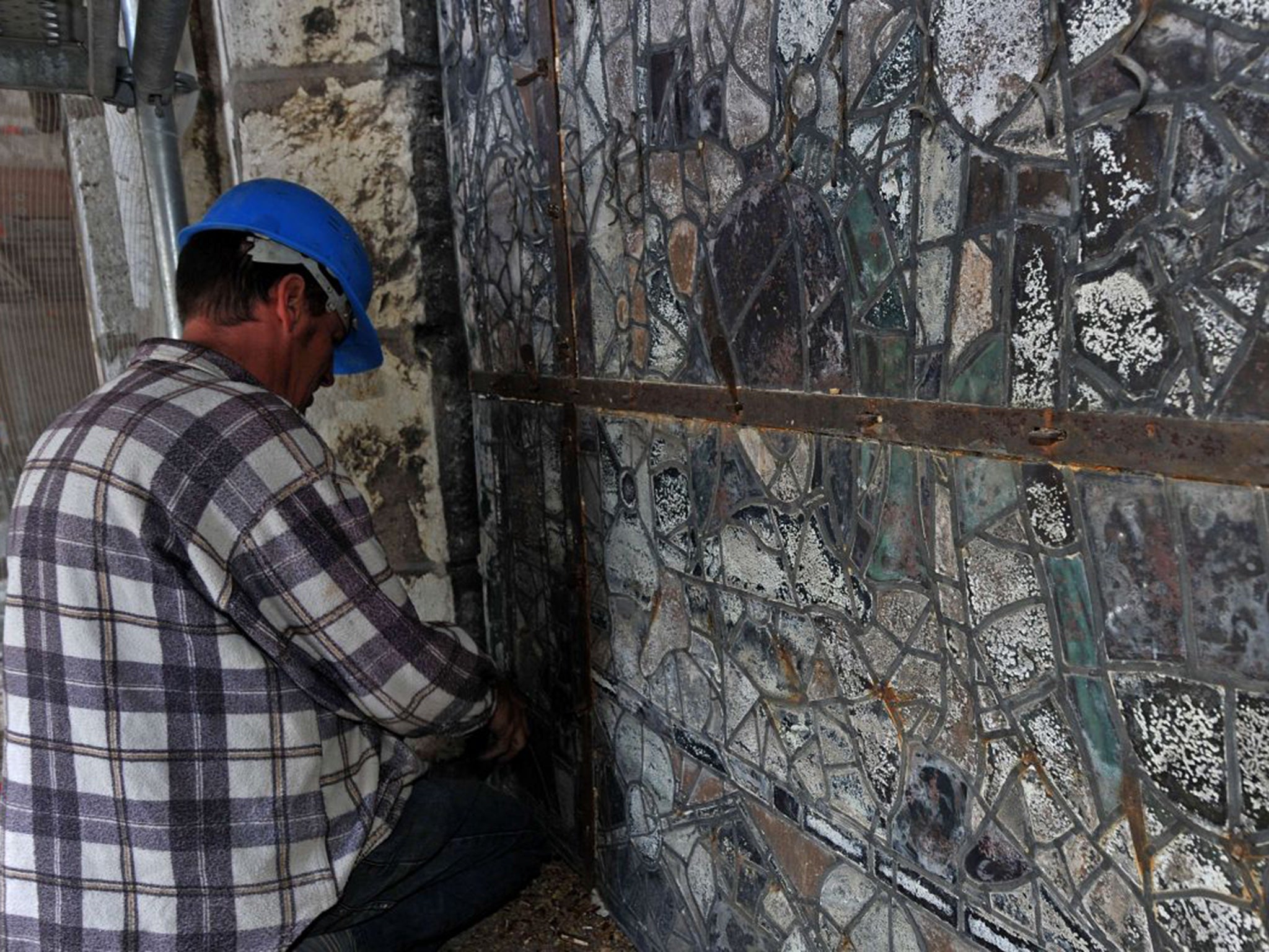 A worker restores stained glass at Chartres Cathedral during renovation work on September 15, 2015
