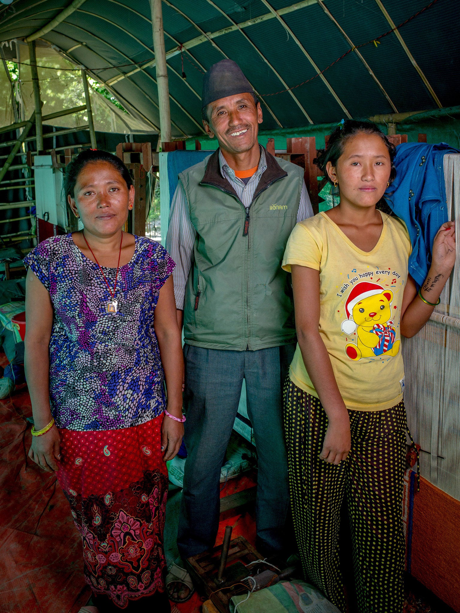 Damay Singh Tamang with his wife Karima and daughter Dolma at their carpet-weaving business in Bode camp