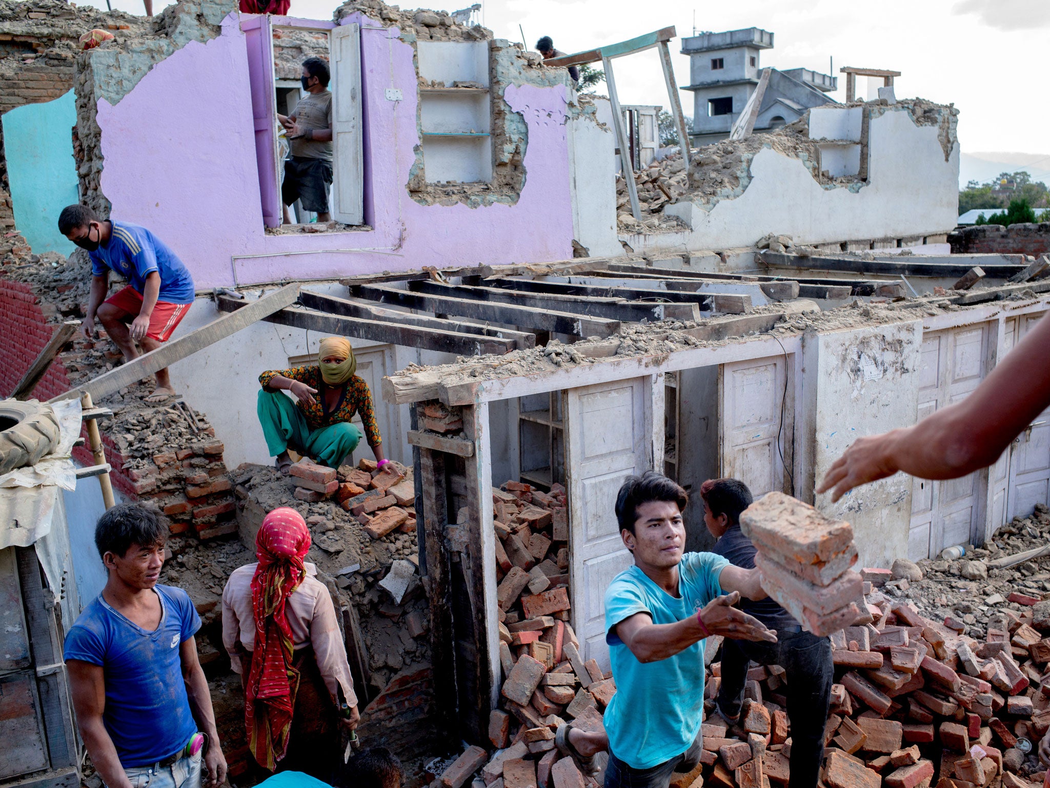 Villagers from Bode dismantle a house destroyed in the earthquake