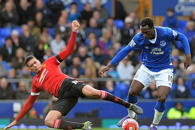 Manchester United defender Chris Smalling challenges Everton's Romelu Lukaku