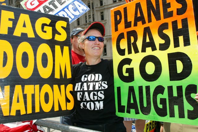 Shirley Phelps-Roper holds up signs as she joins fellow members of the Westboro Baptist Church