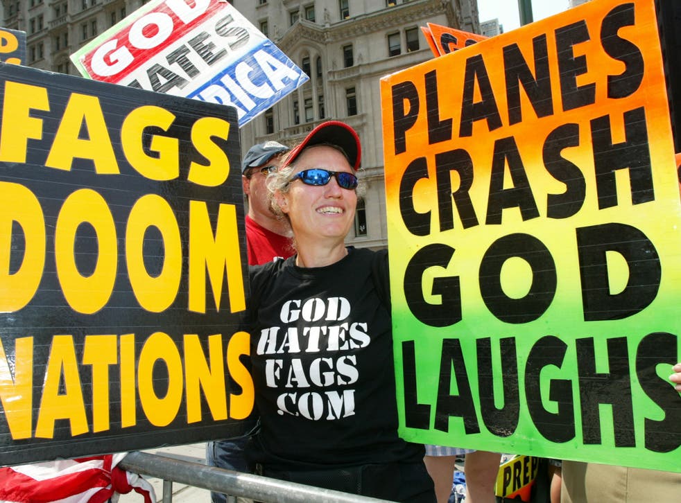 Shirley Phelps-Roper holds up signs as she joins fellow members of the Westboro Baptist Church