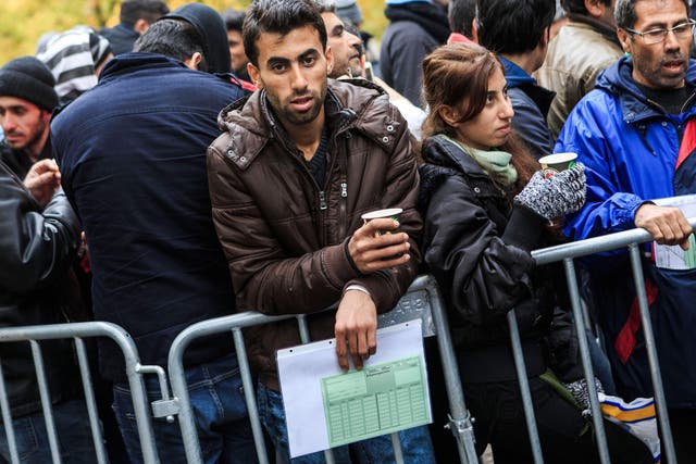 A man seeking refugee status waits to register outside the Central Registration Office for Asylum Seekers in Berlin