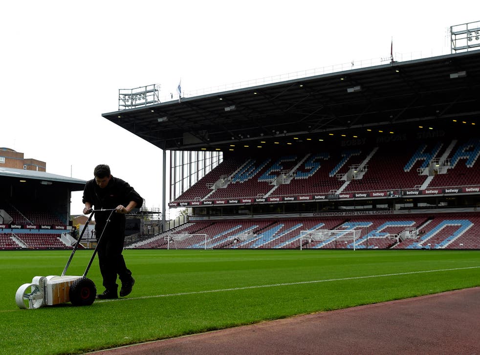 A groundsman at Upton Park prepares the pitch for the pick of today's 3 o'clock kick-offs