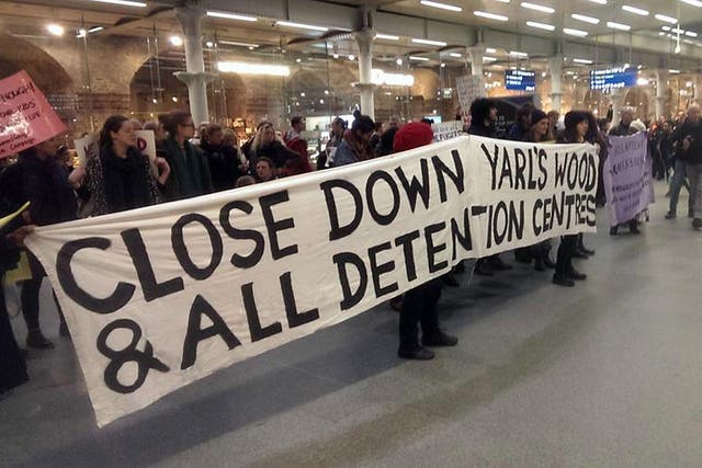 Protesters hold up a banner calling for the closure of the Yarls Wood detention centre at Kings Cross St Pancras station