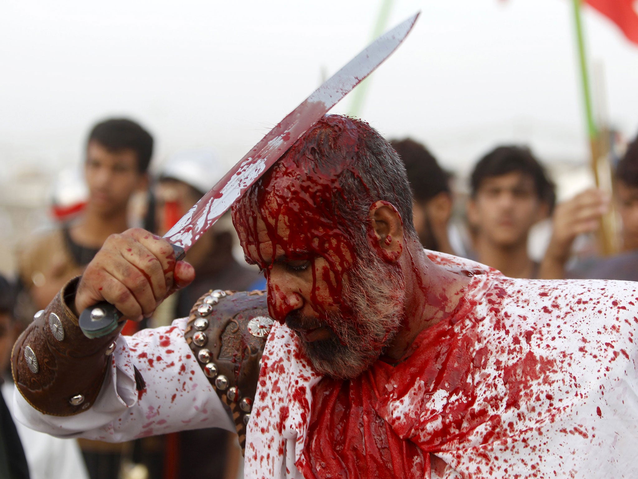 Iraq Shi'ite Muslim men bleed as they slice their foreheads with swords and beat themselves to commemorate Ashura in Sadr City, Baghdad.