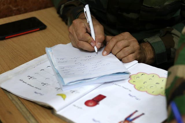 An Iraqi Kurdish Peshmerga fighter attends a night school in Iraq. The location of the classes is a closely guarded secret in order to protect the students