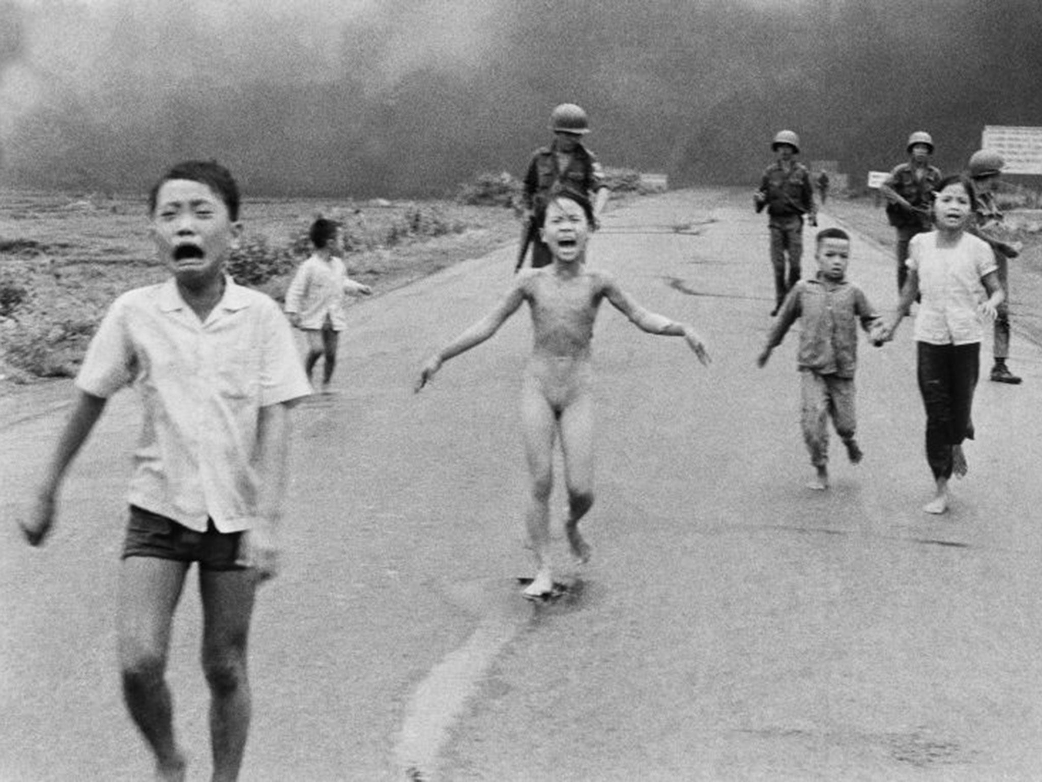 9-year-old Kim Phuc, center, runs with her brothers and cousins, followed by South Vietnamese forces