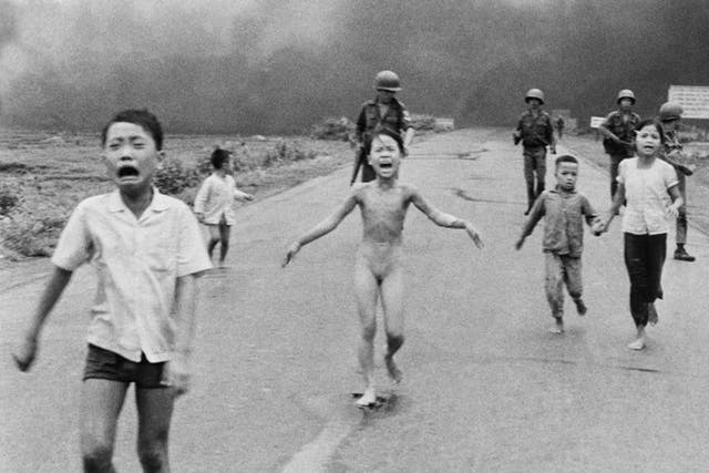  9-year-old Kim Phuc, center, runs with her brothers and cousins, followed by South Vietnamese forces