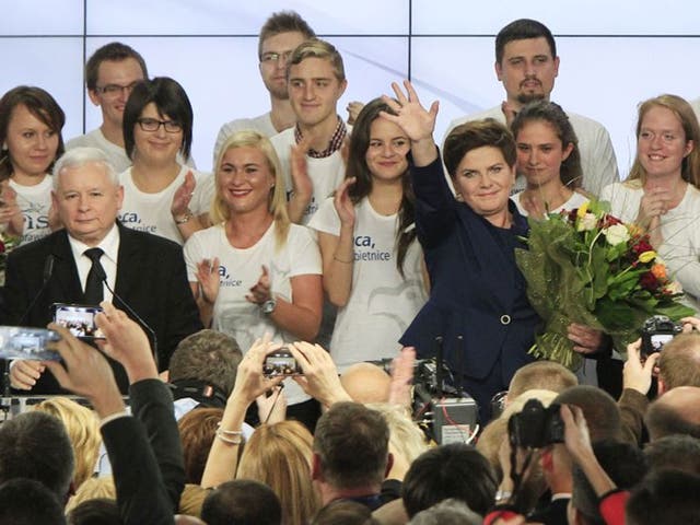 Conservative Law and Justice leader Jaroslaw Kaczynski, left, and Justice candidate for the Prime Minister Beata Szydlo ,right, wave during the general election in Poland at the party's headquarters in Warsaw