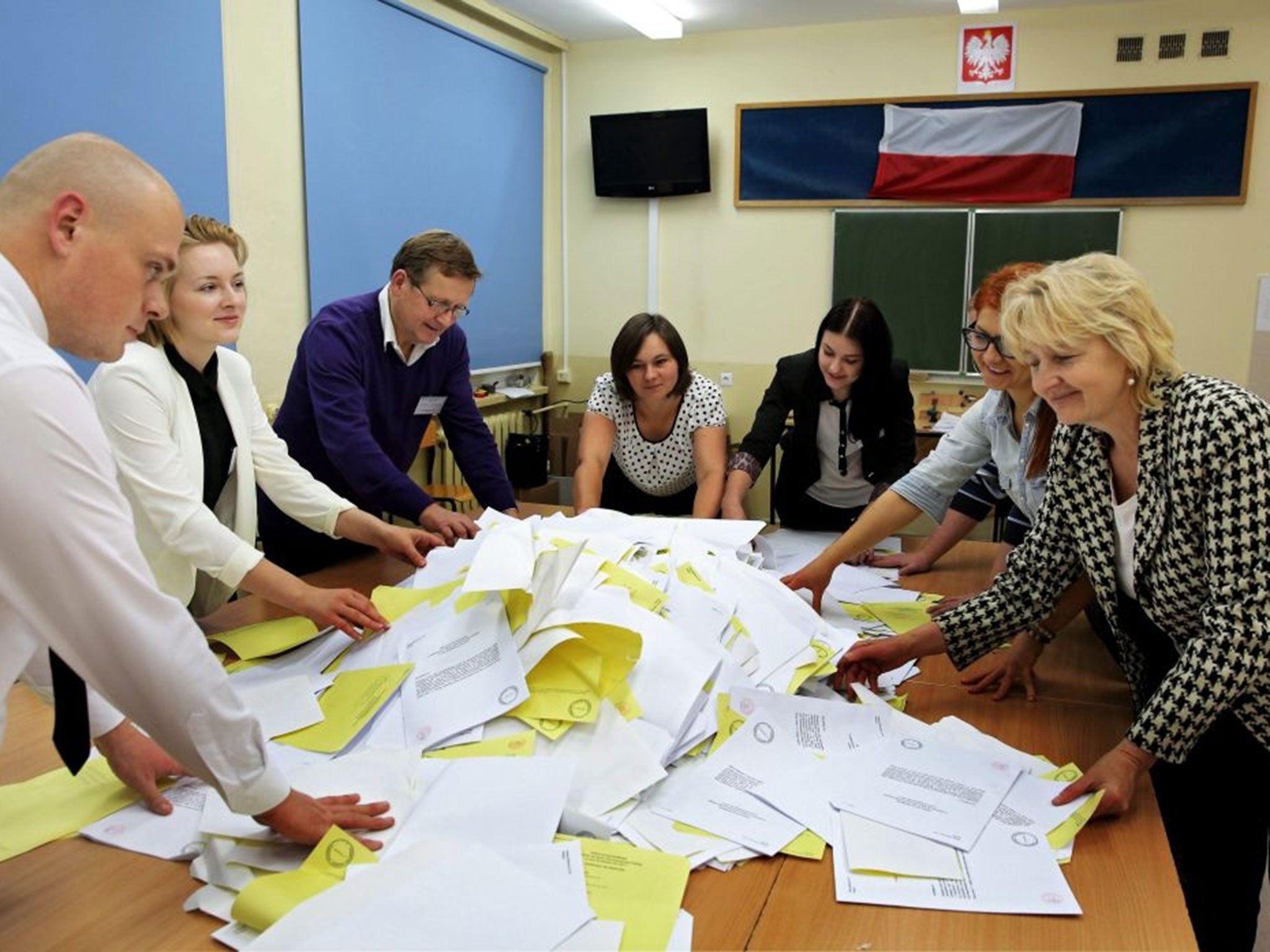 Polling officials count votes cast in Poland's parliamentary elections in one of the polling stations in Olsztyn