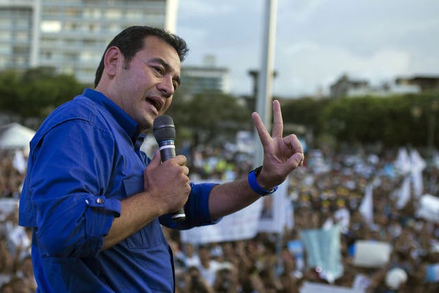 In this Thursday, Oct. 22, 2015 photo, Jimmy Morales, the National Front of Convergence party presidential candidate, gives a victory sign as he speaks to supporters during a campaign rally in Guatemala City