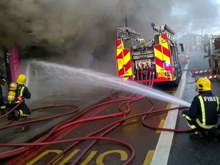 London Fire Brigade crews have rescued 25 people - including two from the roof - of a shop and flats on fire in Finchley Road