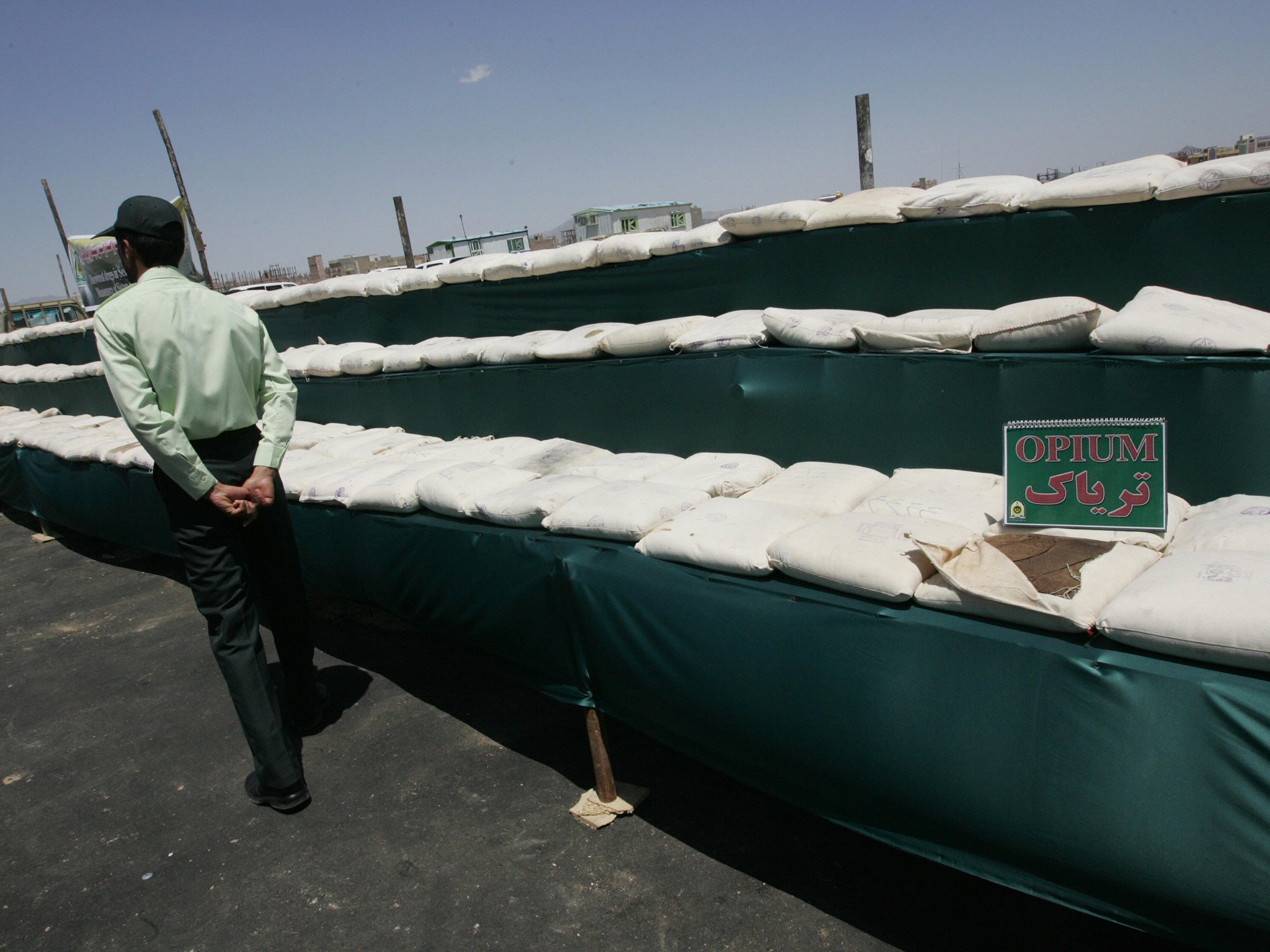 Iranian policeman guards the 3000 kilograms of opium seized from the drug smugglers in the southeastern city of Zahedan