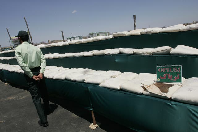 Iranian policeman guards the 3000 kilograms of opium seized from the drug smugglers in the southeastern city of Zahedan