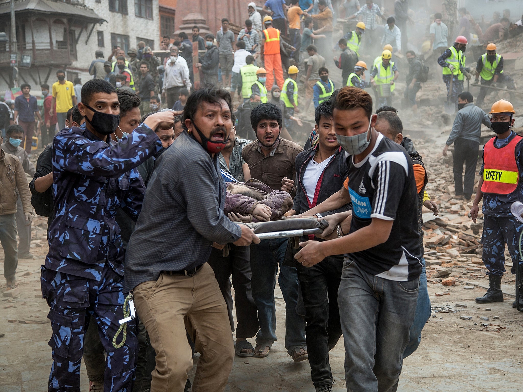 Emergency rescue workers carry a victim on a stretcher after Dharara tower collapsed in Kathmandu, Nepal, in April 2015