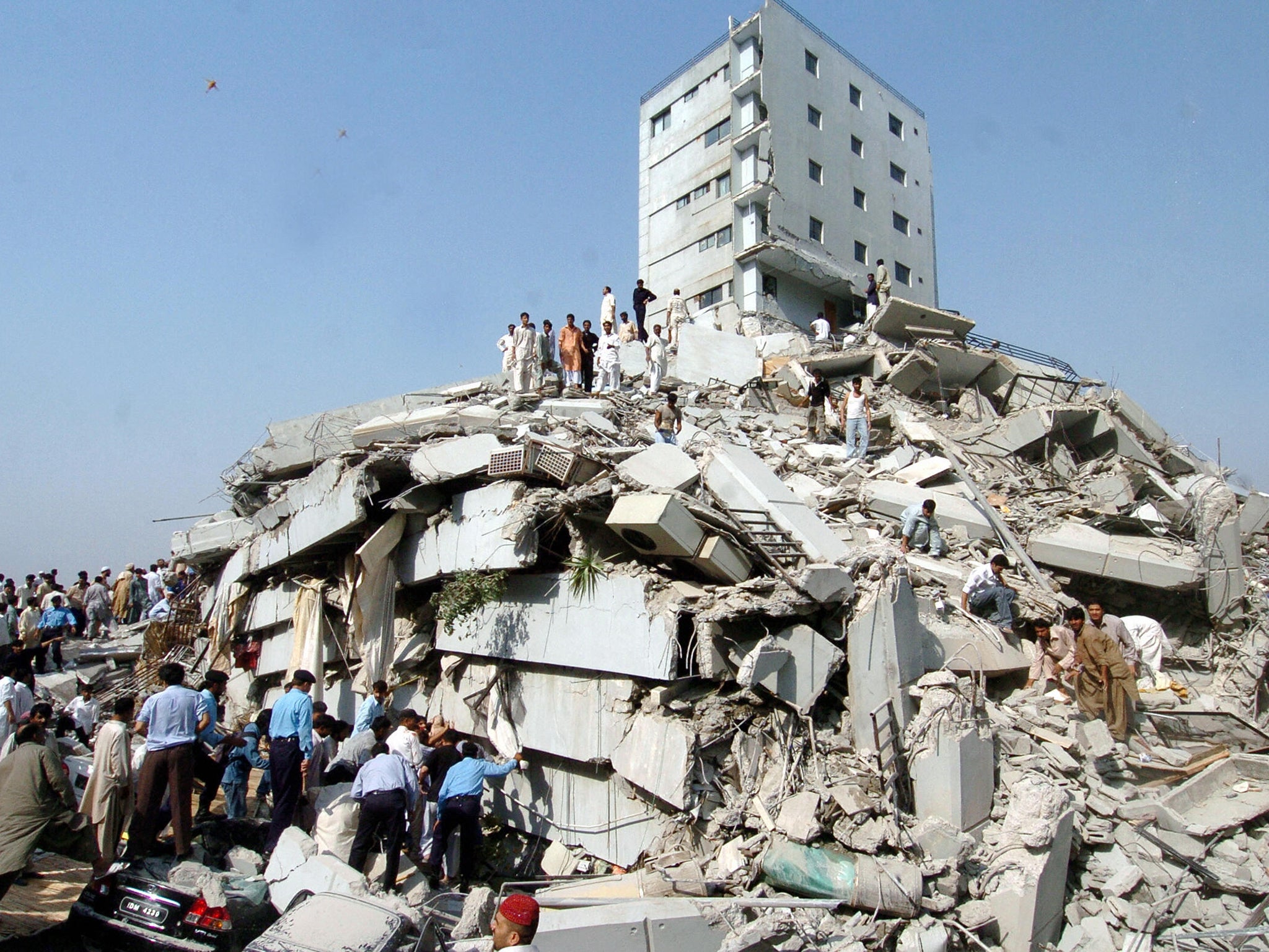 Residents search the wreckage of a building hit by a strong earthquake in Islamabad in October 2005