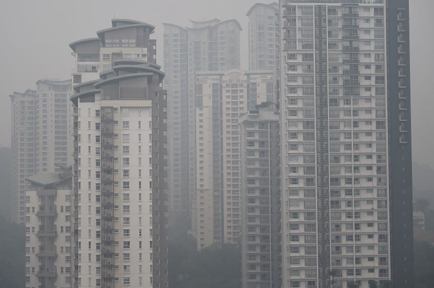 Blocks of flats in Kuala Lumpur are enveloped in smoke produced by forest fires (AFP)