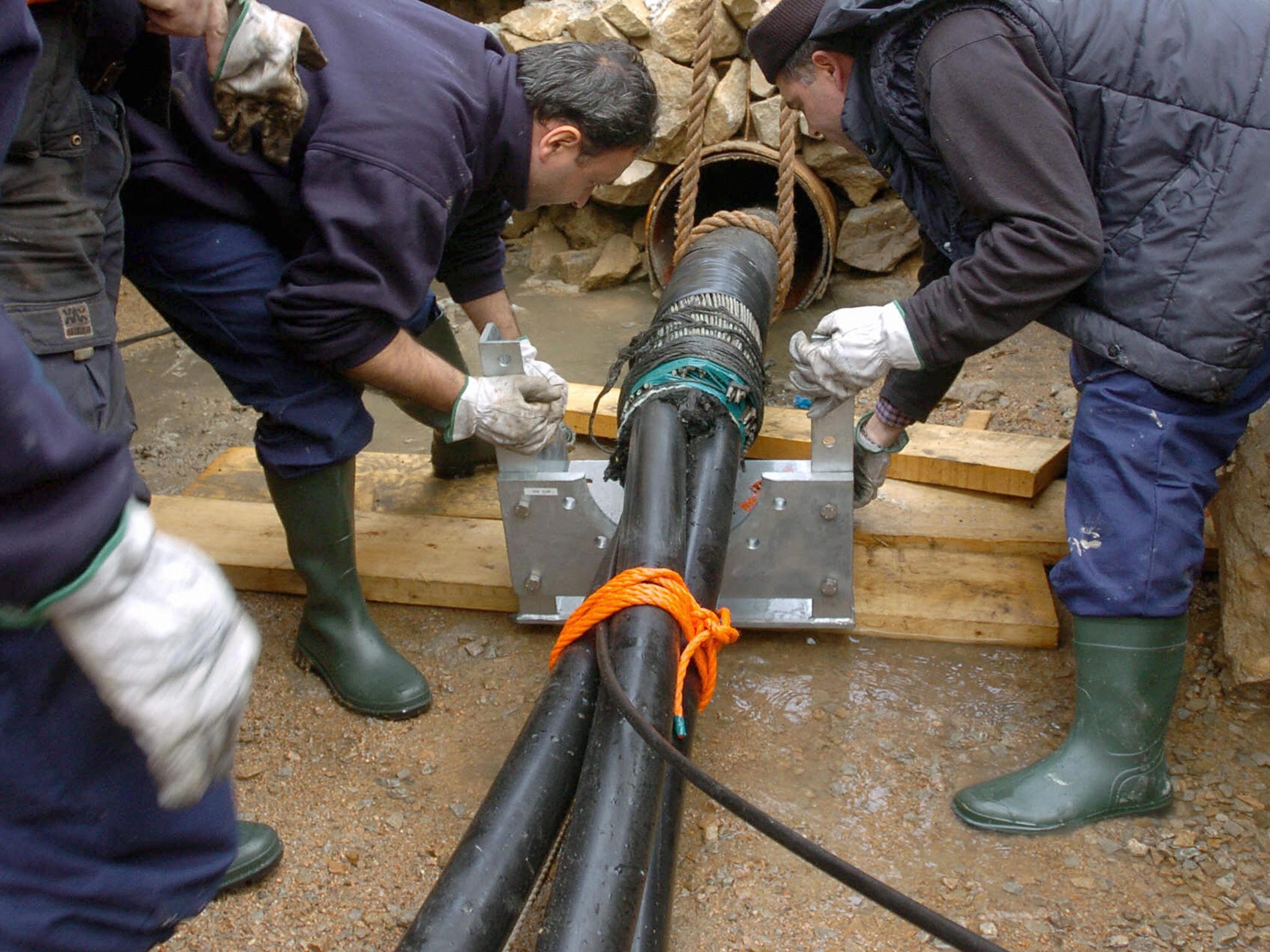 Italian technicians manipulate a high-tension under-sea fiber-optic cable