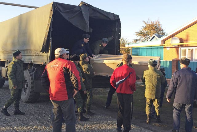 Russian servicemen unload a coffin containing the body of Vadim Kostenko from a truck near his family's home in the village of Grechnaya Balka, north-west of Krasnodar, Russia