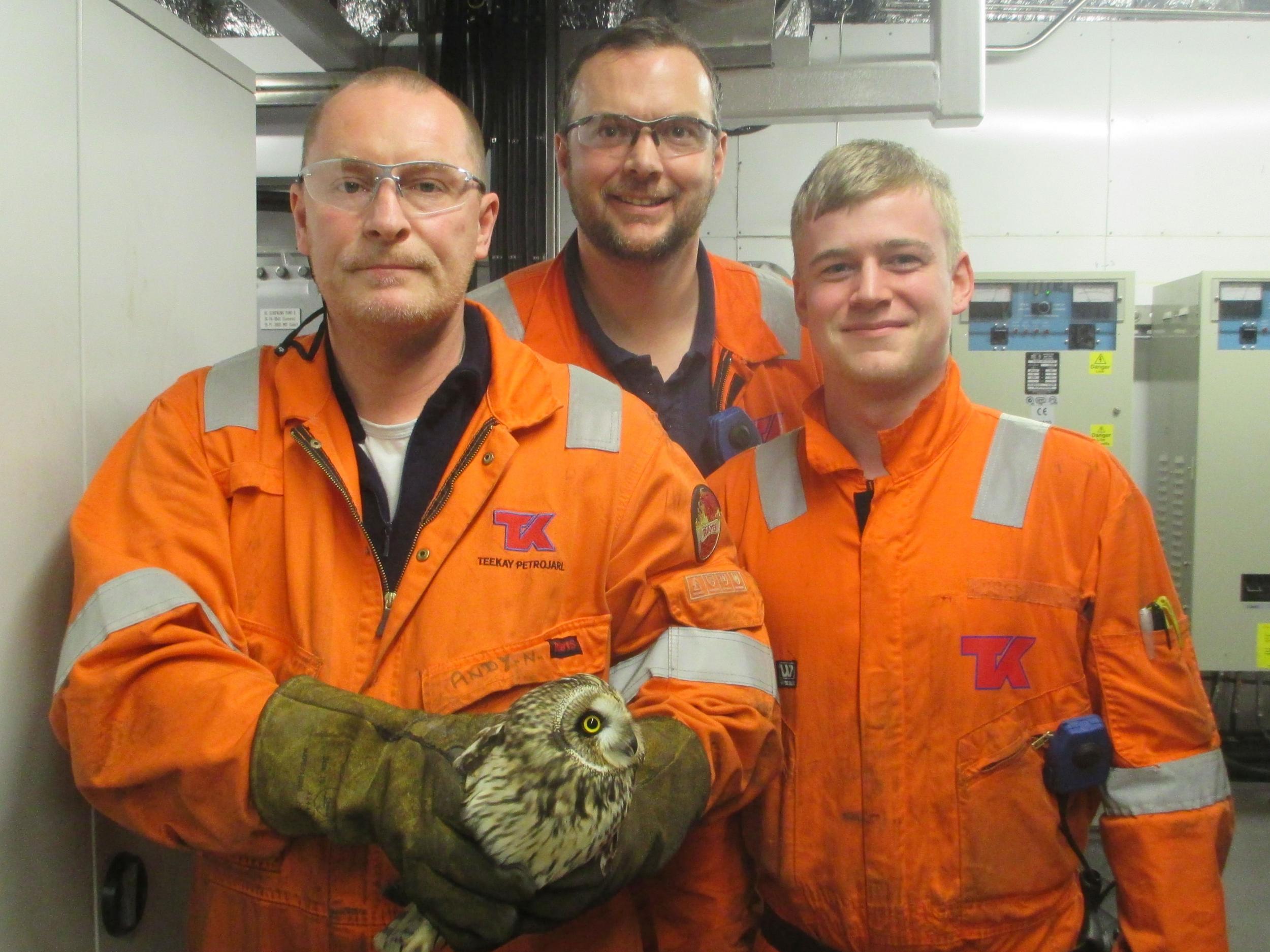 The proud rescuers on the oil rig with the owl