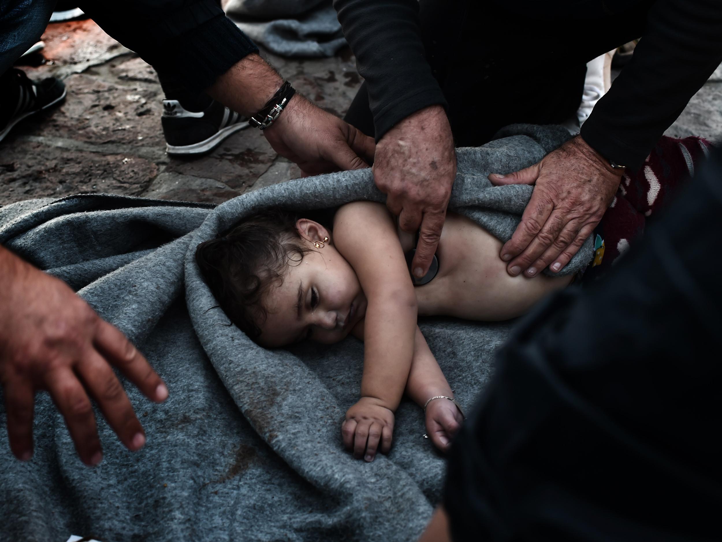 Doctors and paramedics treat a child after boat with refugees and migrants sunk while attempting to reach the Greek island of Lesbos from Turkey