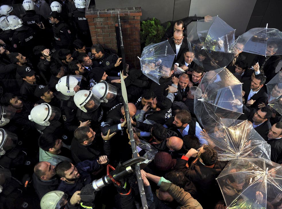 Employees block the door as riot police try to enter Kanalturk and Bugun TV building in Istanbul, Turkey, October 28, 2015