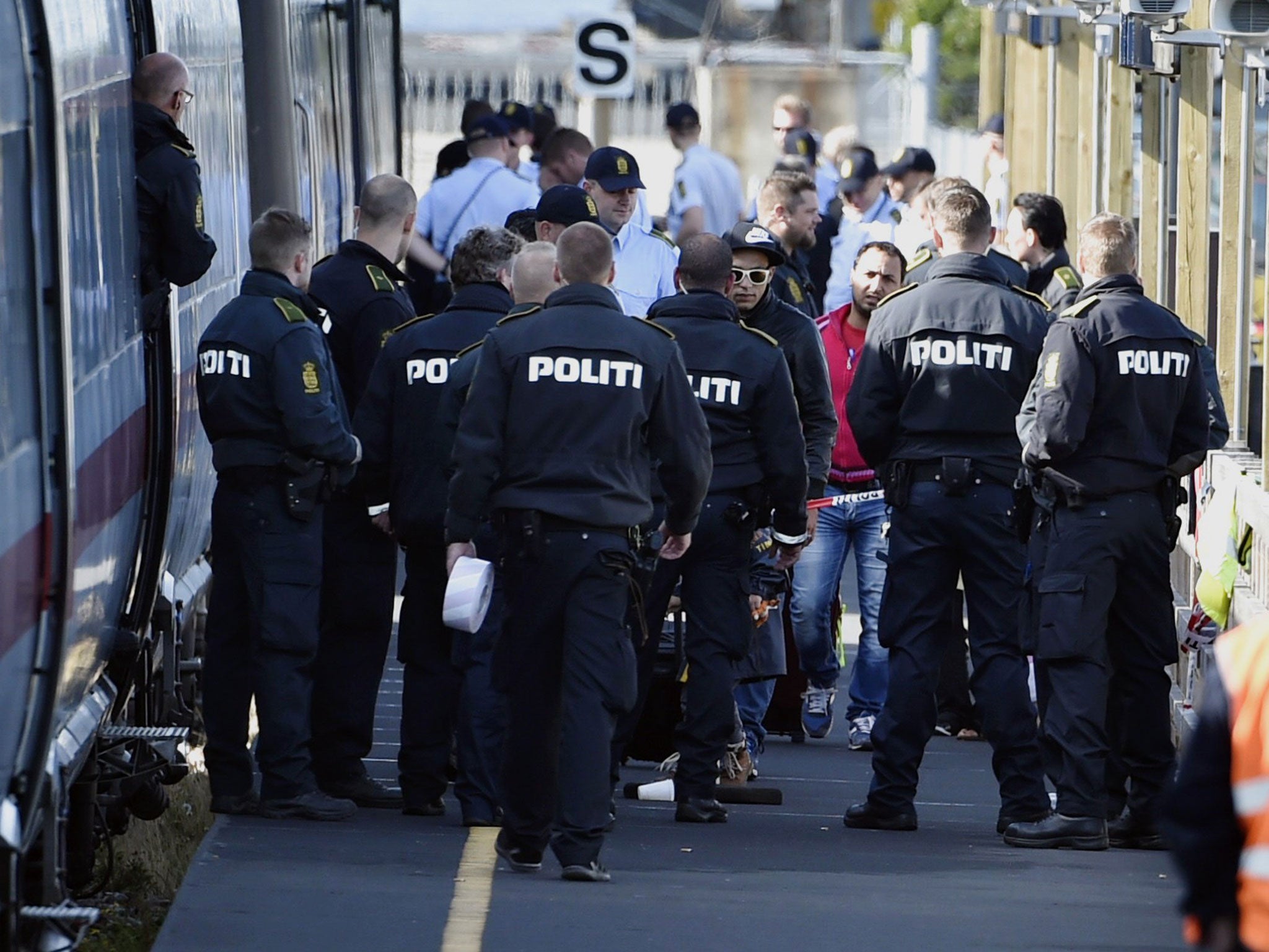 Police with migrants and refugees at a railway station in Demnark