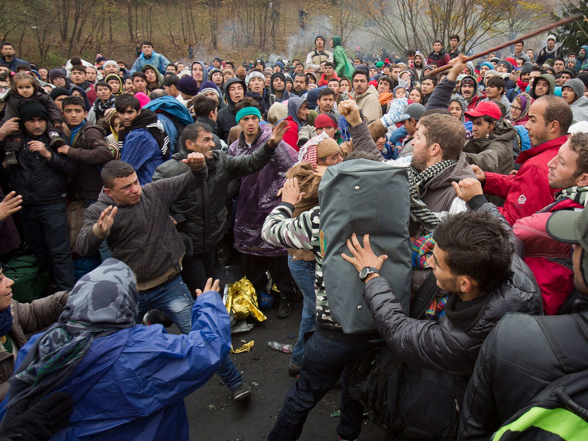 Refugees scuffle in Sentilj, Slovenia, as they wait to cross the border into Austria