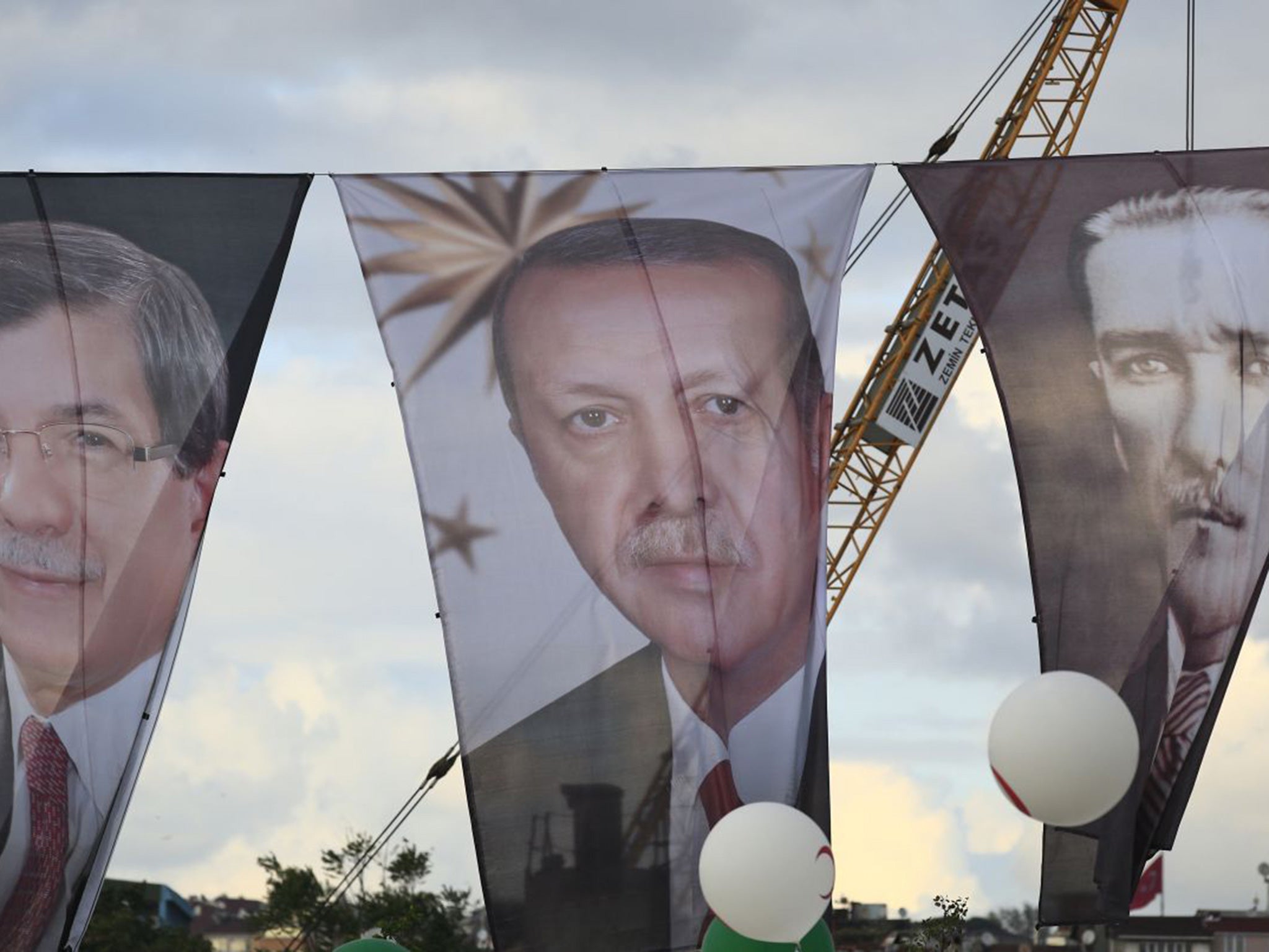 Banners from left to right show Turkish Prime Minister Ahmet Davutoglu, leader of the Justice and Development Party (AKP), Turkey's current President Recep Tayyip Erdogan' and Turkish Republic founder Mustafa Kemal Ataturk