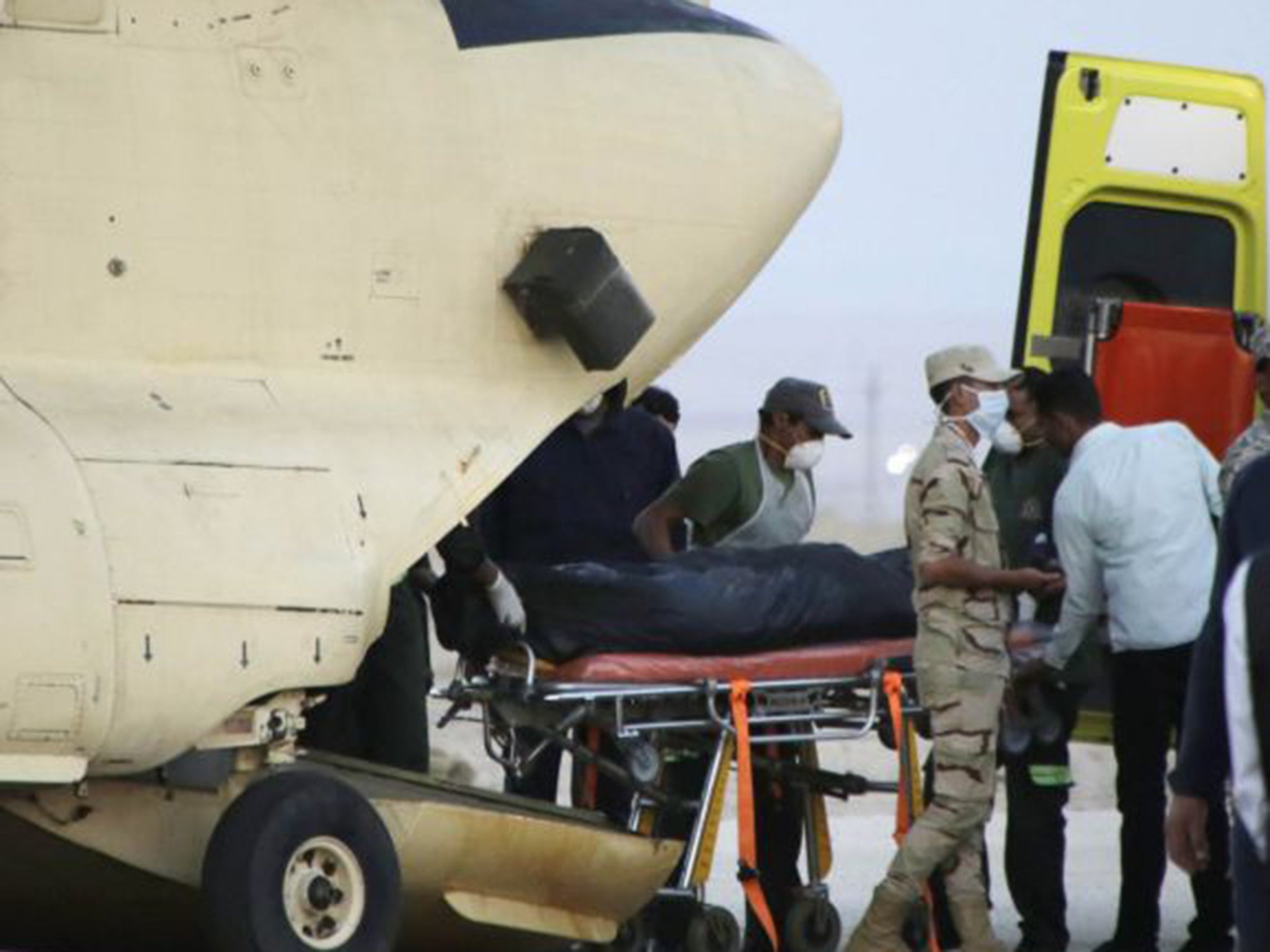 Egyptian paramedics load a body on to a plane at Kabret air base