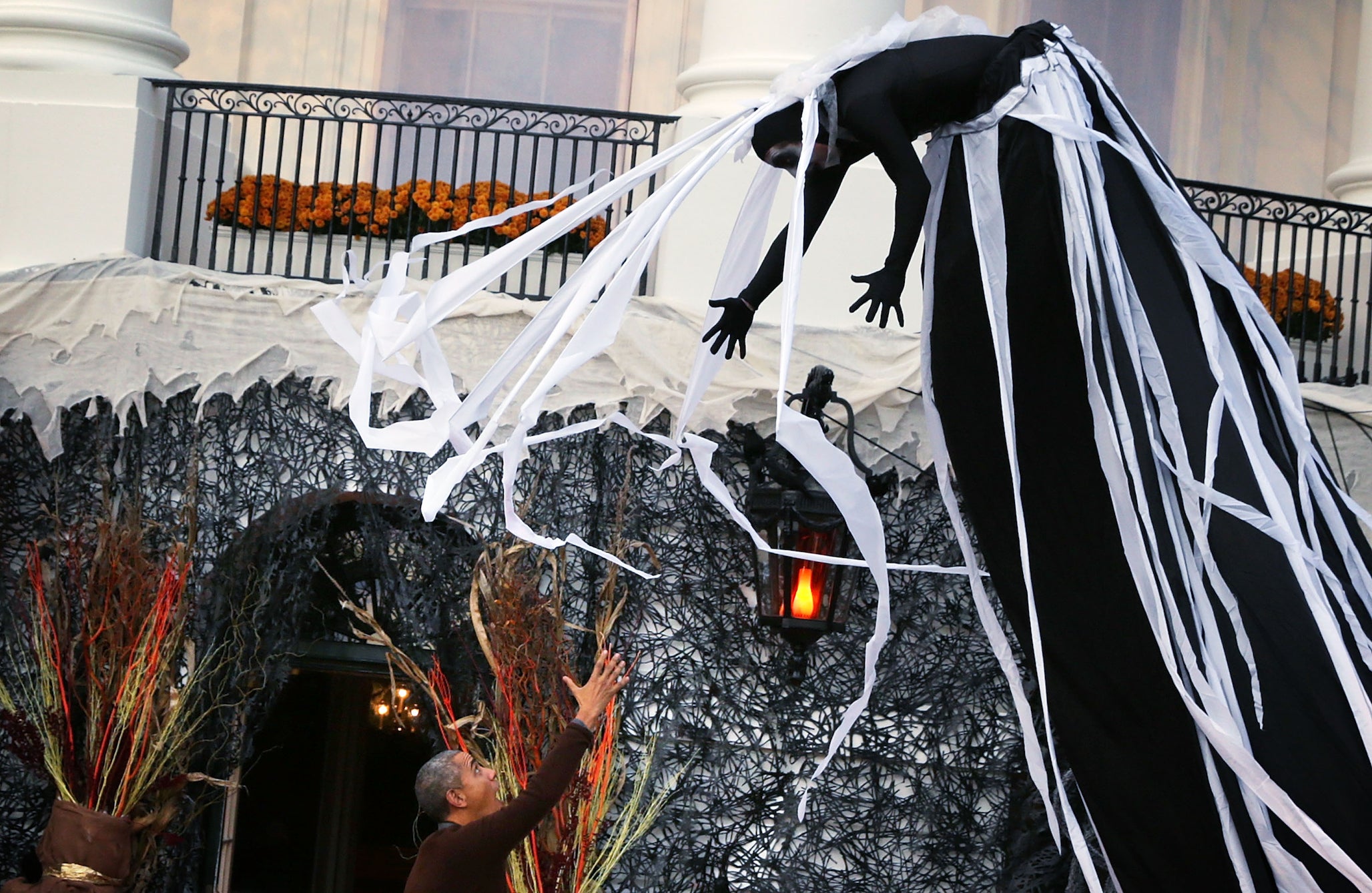A performer suspended above U.S. President Barack Obama (L) during a Halloween event at the South Lawn of the White House October 30, 2015 in Washington, DC