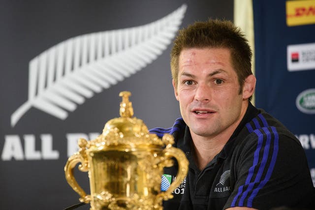 New Zealand captain Richie McCaw sits with the Webb Ellis Cup