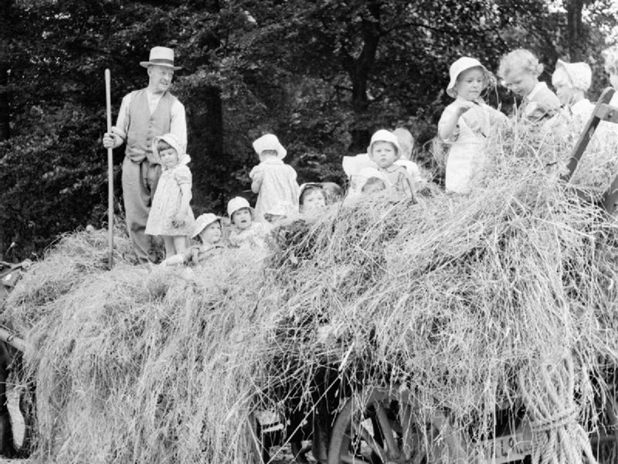 A group of young evacuees sit on a hay cart outside Chapel Cleeve Nursery in Washford Somerset