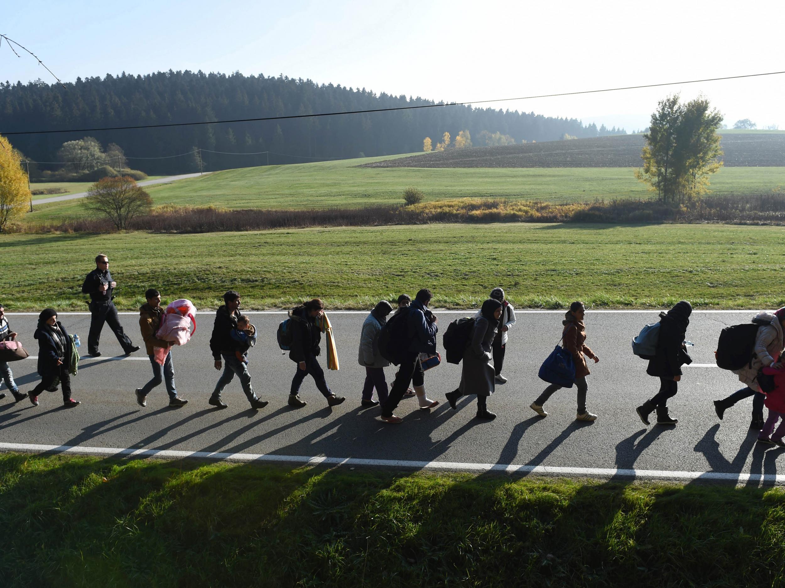 Migrants walk on the road after crossing the Austrian-German border in southern Germany