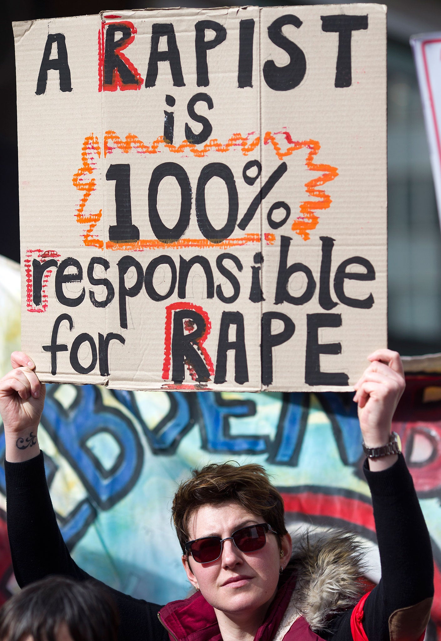 A woman holds a placard during a demonstration to protest against violence towards women on International Women's Day in London