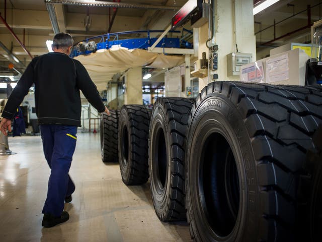 A worker controls truck tyres in the Michelin factory on december 18, 2014 in Joué-lès-Tours, central France