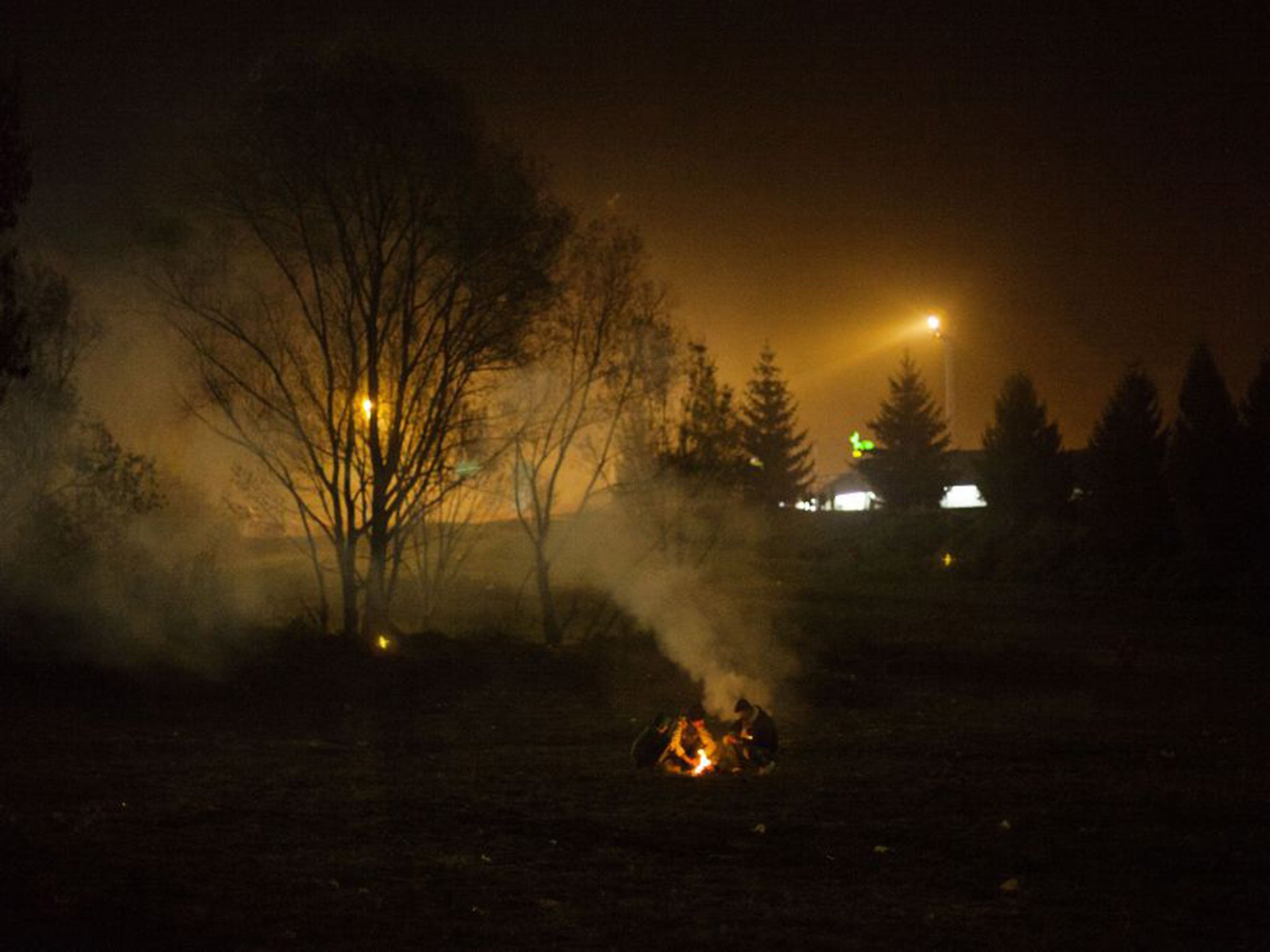 Syrian refugees make a fire while waiting to be allowed to go into Austria at the Slovenian-Austrian border