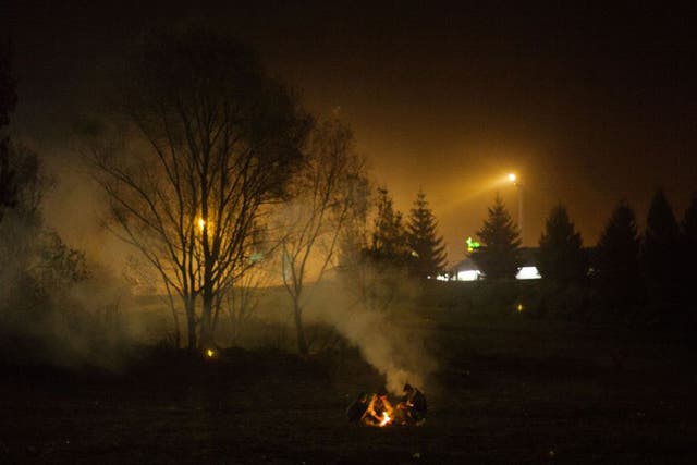 Syrian refugees make a fire while waiting to be allowed to go into Austria at the Slovenian-Austrian border