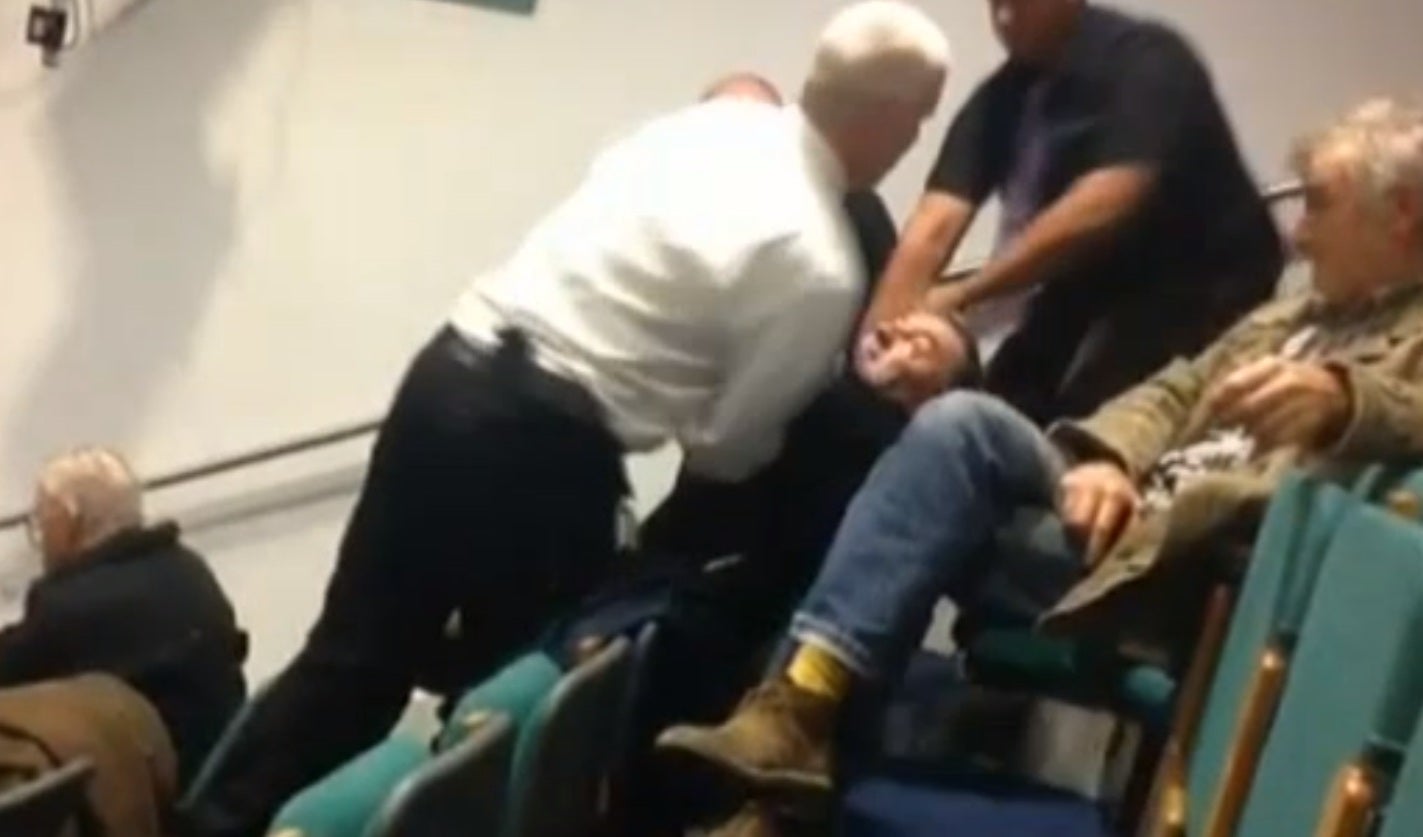 The man is manhandled out of the chamber