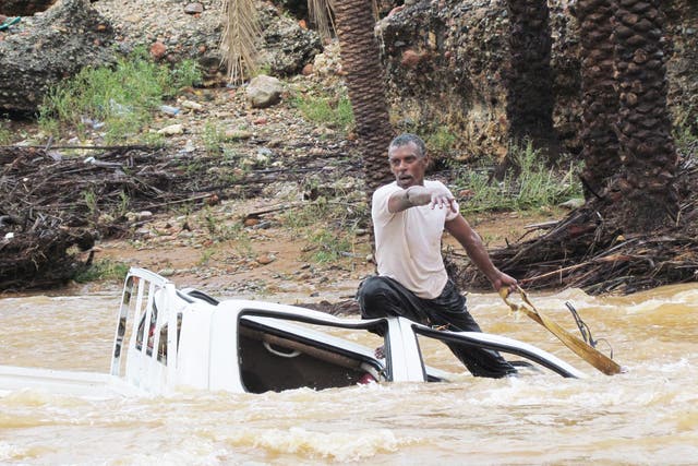 A man tries to save his vehicle as it is swept away by flood waters in Yemen’s island of Socotra